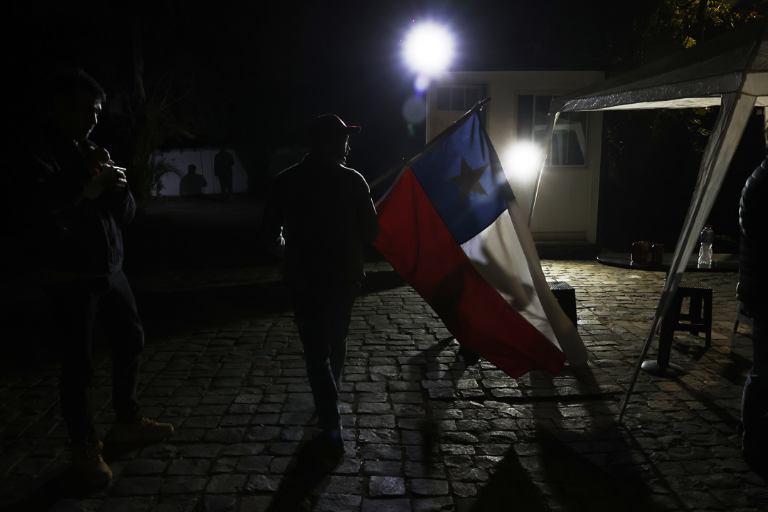 Un hombre con una bandera chilena llega al comando del Partido Republicano en Santiago de Chile