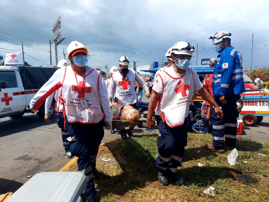Red Cross lifeguards rescue a citizen in a procession in Managua