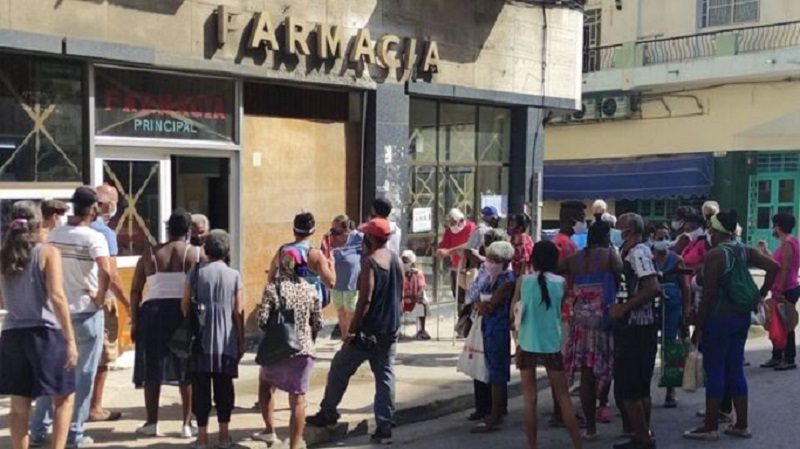 Pobladores cubanos hacen cola frente a una farmacia de barrio en La Habana