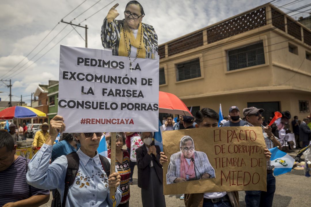 Manifestantes sostienen carteles en una protesta frente a la sede del Ministerio Público en Ciudad de Guatemala