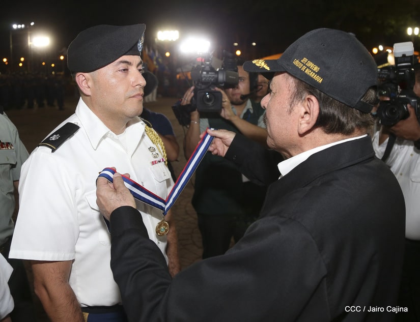 Daniel Ortega colocando la medalla a William Hogan