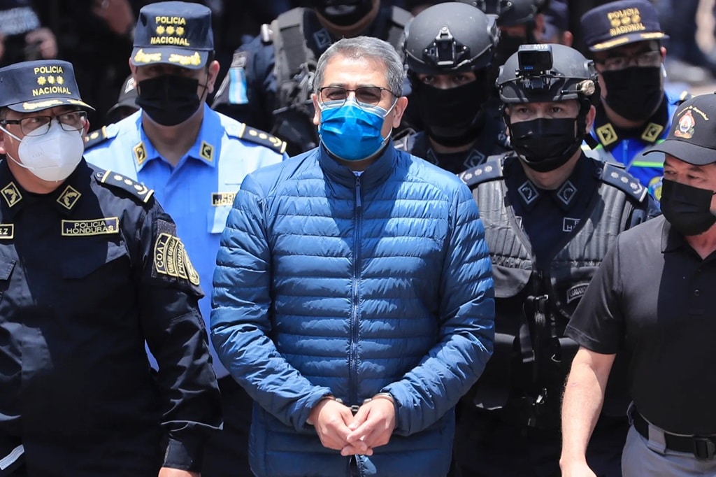 Police guard former Honduran president, Juan Orlando Hernández, on his way to extradition to the U.S. in 2022. Photo: EFE