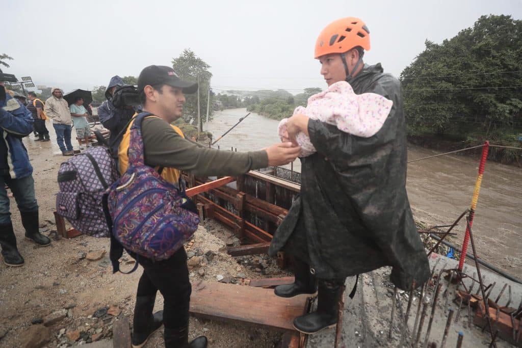 Militares y cuerpos de socorro de Honduras ayudan a evacuar habitantes por la crecidas de ríos y quebradas por el paso de la tormenta Sara, en el sector de la aldea Tikamaya, en la ciudad de San Pedro Sula.