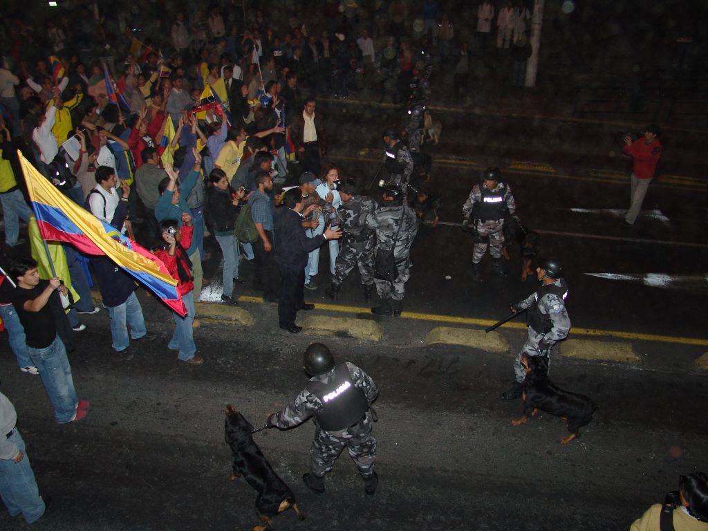 Un grupo de sociedad civil en Ecuador protesta frente a agentes policiales.