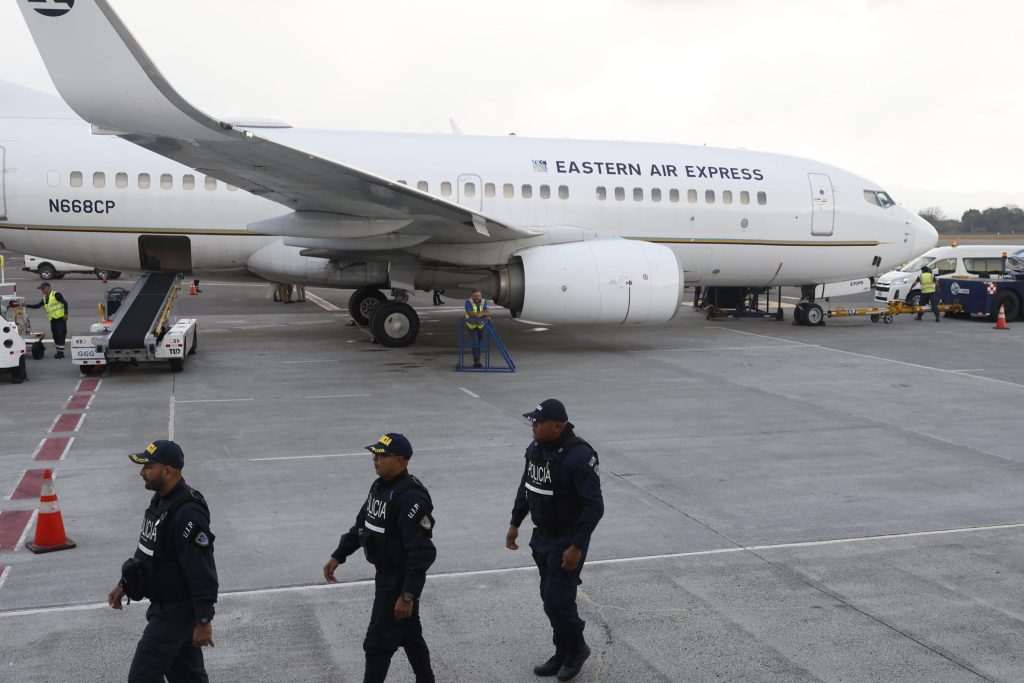 Integrantes de la Fuerza Pública de Costa Rica custodian un avión con migrantes.