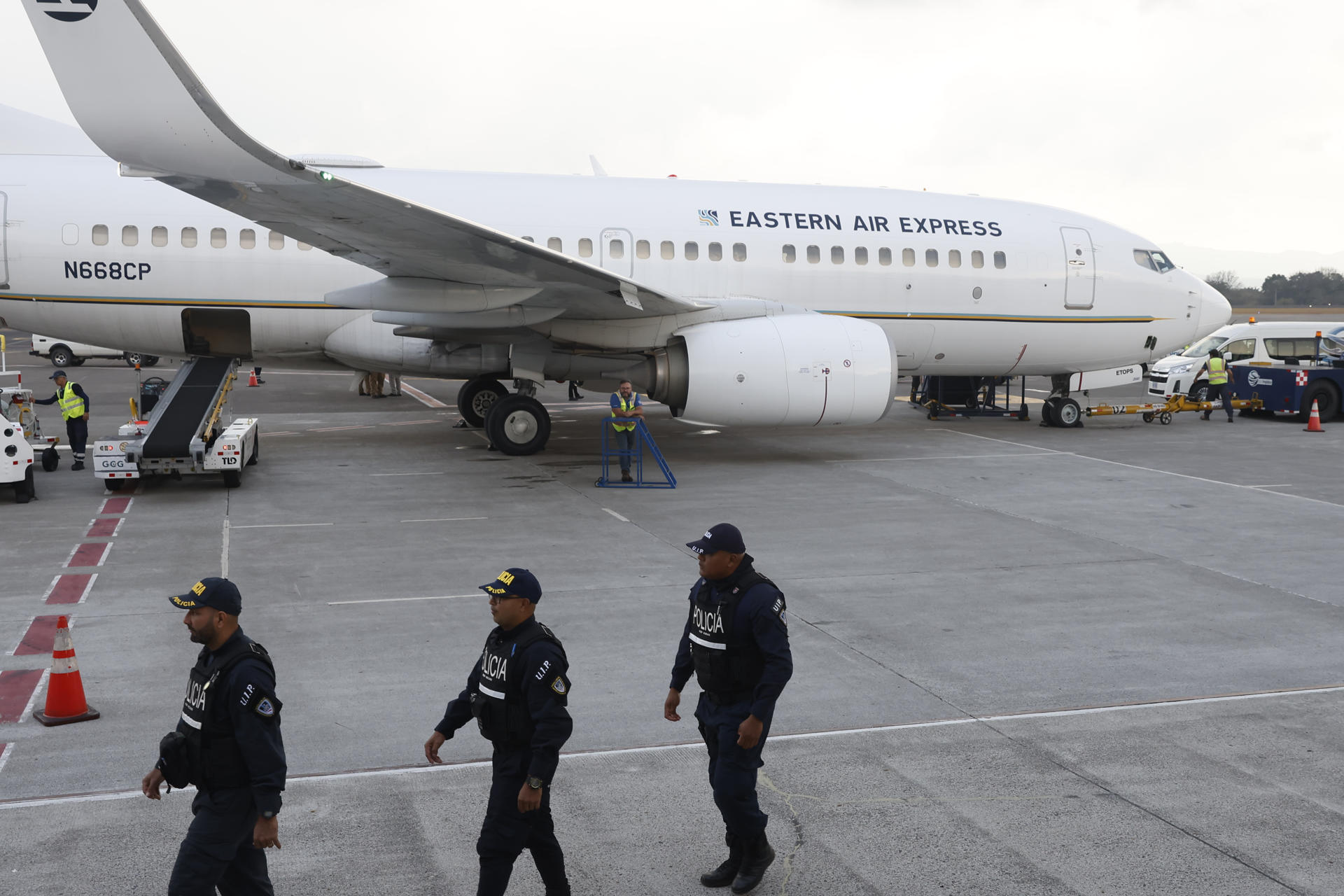 Integrantes de la Fuerza Pública de Costa Rica custodian un avión con migrantes.