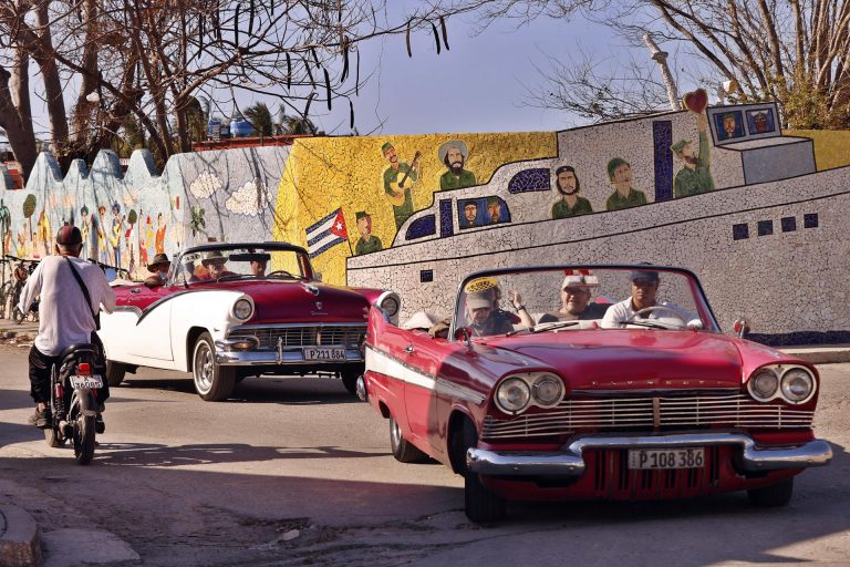 Turistas pasean en autos clásicos en La Habana.