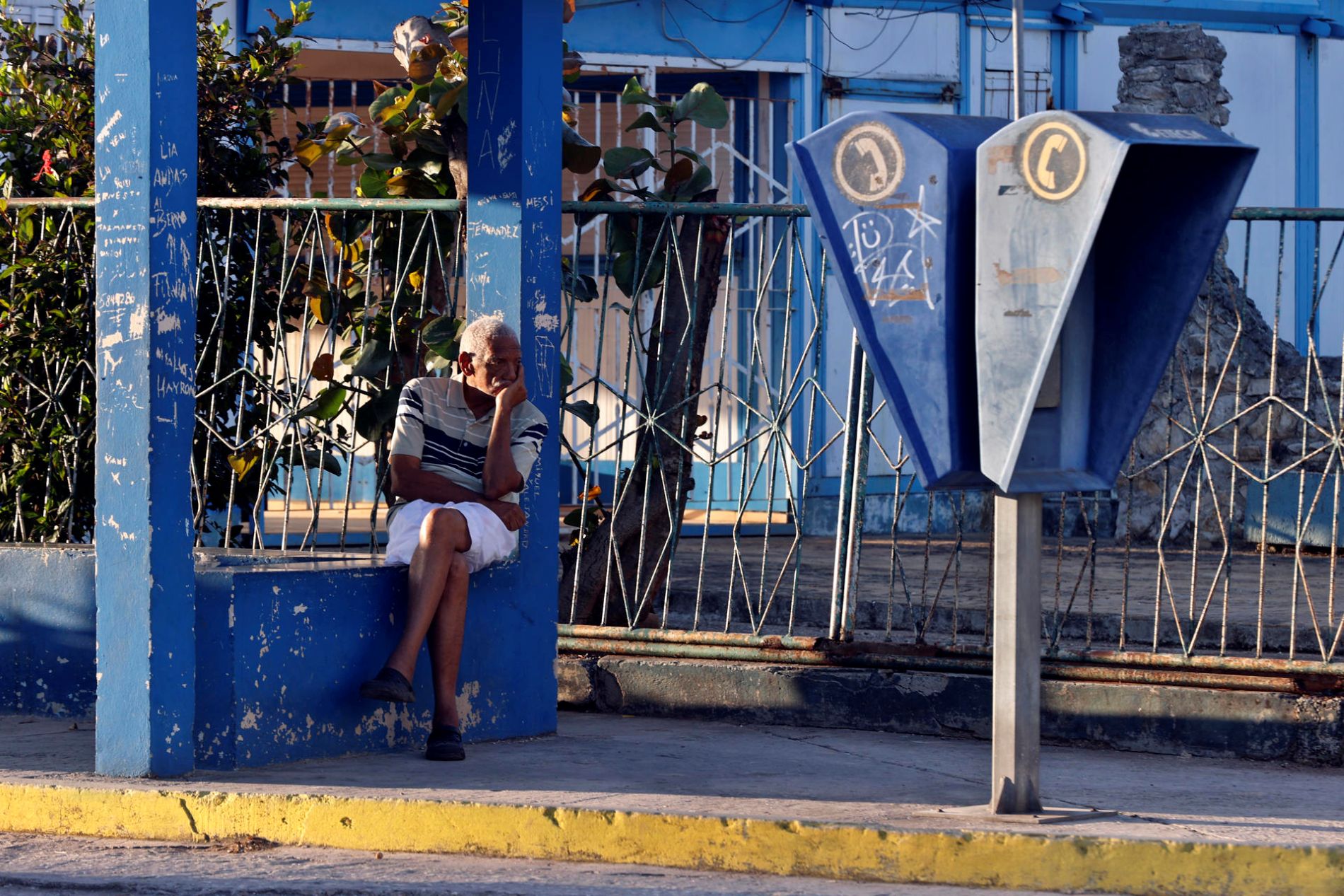 Un adulto mayor espera la llegada de un autobús en La Habana.