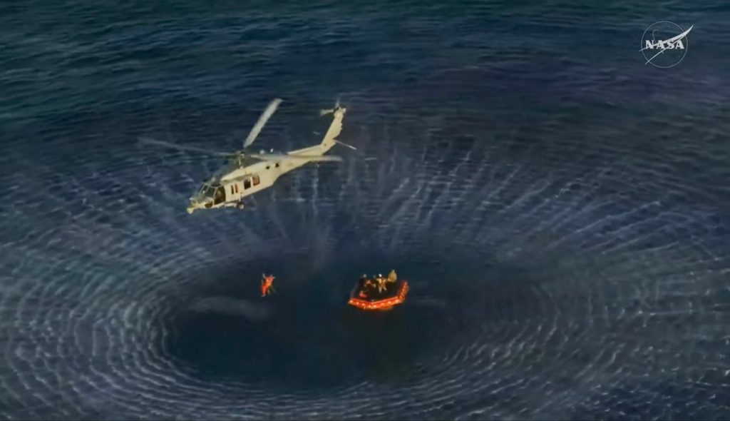 A helicopter carrying an Artemis II crew member