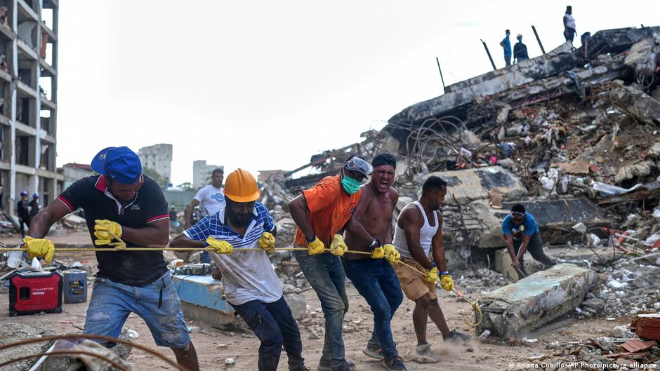 Voluntarios tiran de una cuerda para retirar escombros de un edificio derrumbado en La Guaira