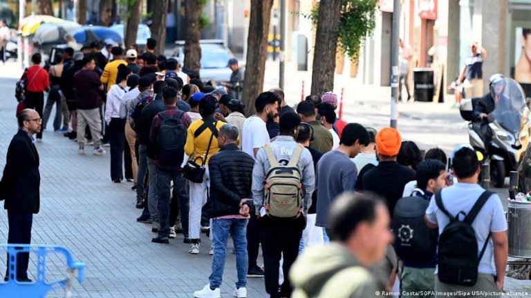 Personas en situación administrativa irregular hacen fila en Barcelona
